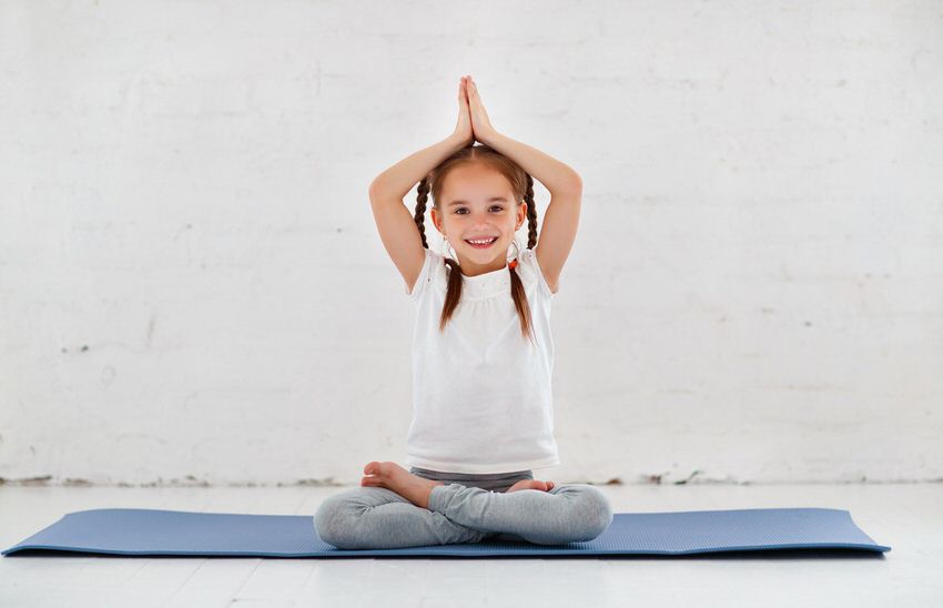 ‘Niños autónomos, adultos inteligentes’ escrito por Olimpia Tarda - Niña haciendo yoga en un aula Montessori - International Montessori School en Sotogrande, Cádiz